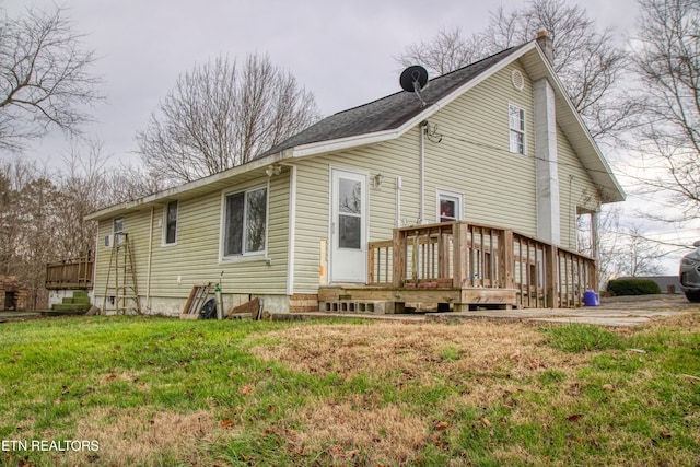 back of property featuring a lawn and a wooden deck