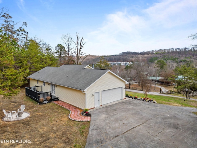 view of side of home featuring a garage and a wooden deck