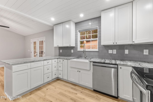 kitchen with kitchen peninsula, white cabinetry, light wood-type flooring, and appliances with stainless steel finishes