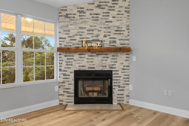 details with hardwood / wood-style floors and a large fireplace