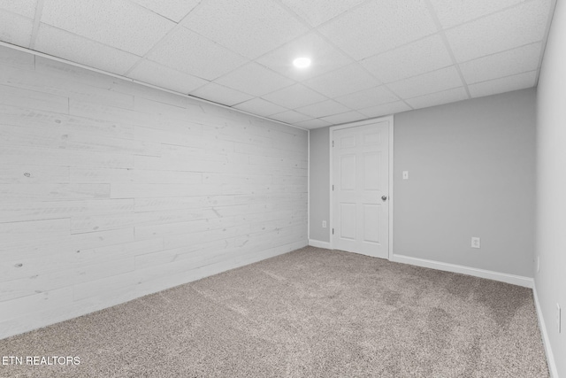 spare room featuring a paneled ceiling and carpet floors