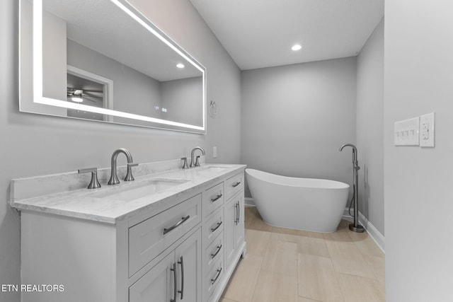 bathroom with a bathing tub, vanity, and ceiling fan