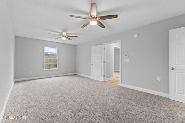 carpeted spare room with ceiling fan and a textured ceiling