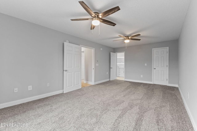 carpeted empty room featuring ceiling fan and a textured ceiling