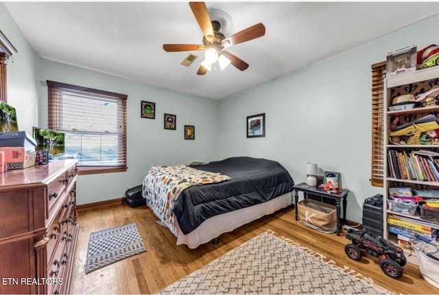 bedroom with light hardwood / wood-style floors and ceiling fan