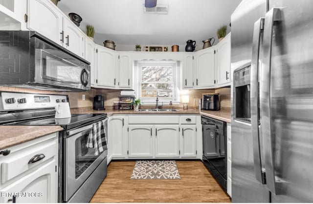 kitchen featuring white cabinetry, sink, light hardwood / wood-style floors, and black appliances