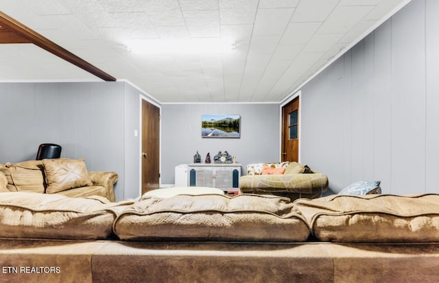 living room featuring crown molding and wood walls