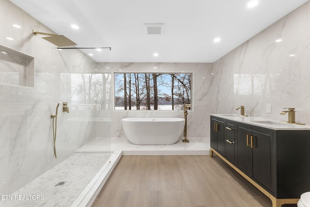 bathroom featuring vanity, independent shower and bath, tile walls, and hardwood / wood-style flooring