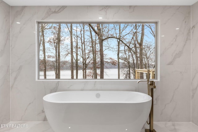 bathroom featuring a tub and tile walls