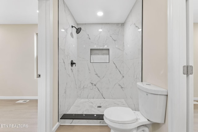 bathroom with a shower, hardwood / wood-style flooring, and toilet