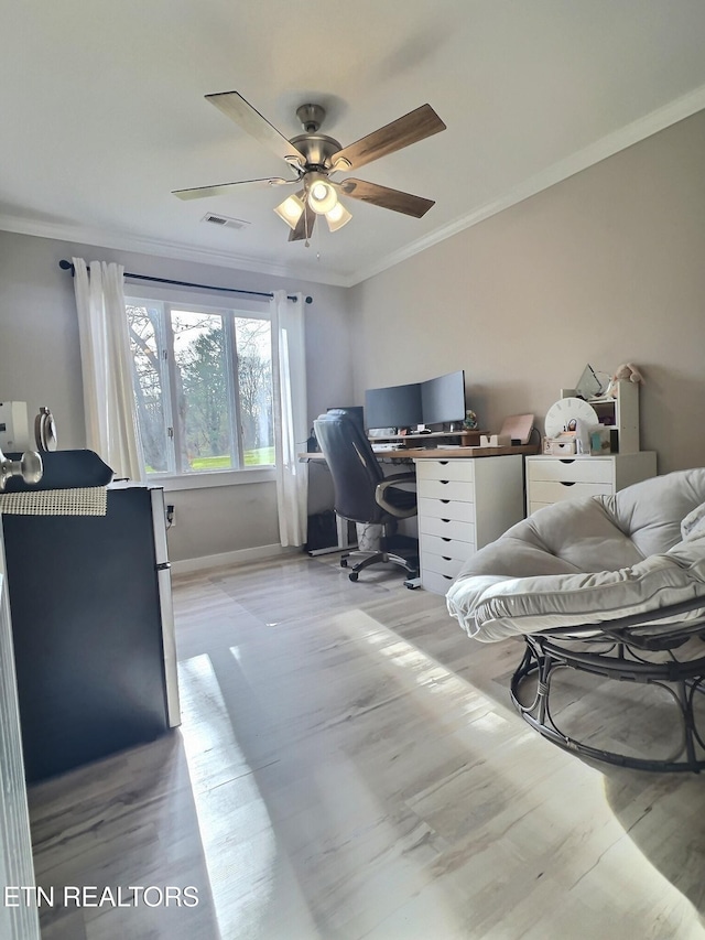 home office featuring light wood-type flooring, ceiling fan, and ornamental molding