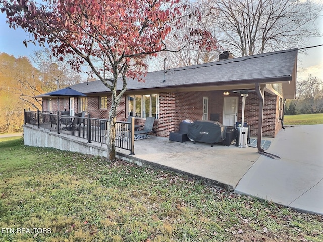 back of property with a lawn and a patio