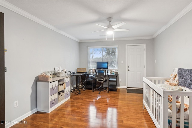 bedroom featuring hardwood / wood-style flooring, a nursery area, ornamental molding, and ceiling fan