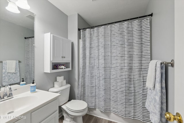 bathroom featuring vanity, hardwood / wood-style flooring, and toilet