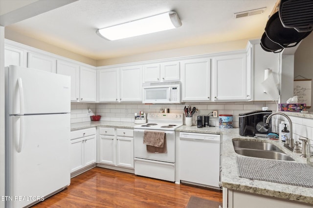 kitchen with decorative backsplash, dark hardwood / wood-style flooring, white appliances, sink, and white cabinets