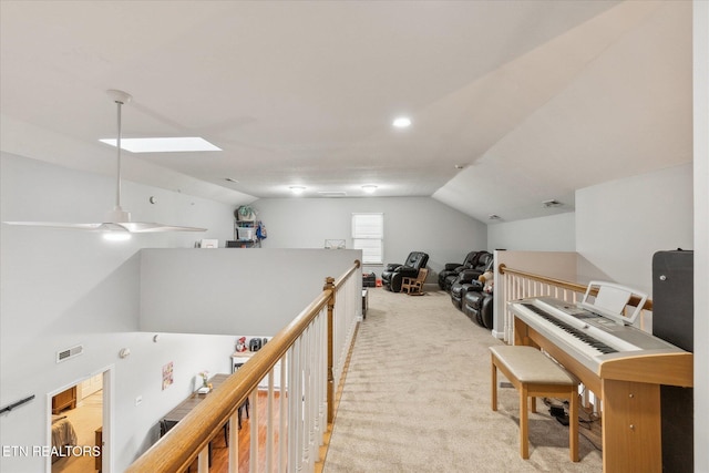 interior space with ceiling fan and lofted ceiling with skylight