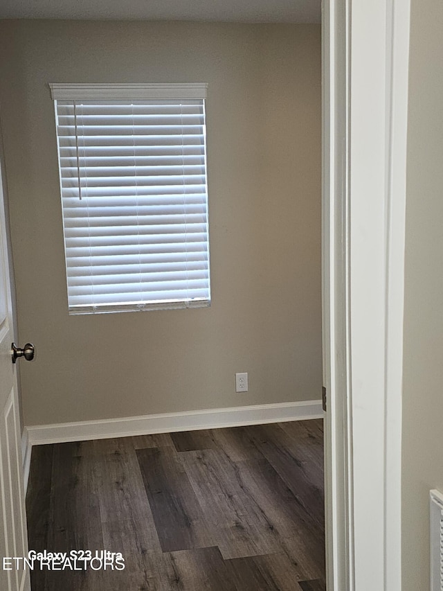 unfurnished room featuring dark wood-type flooring