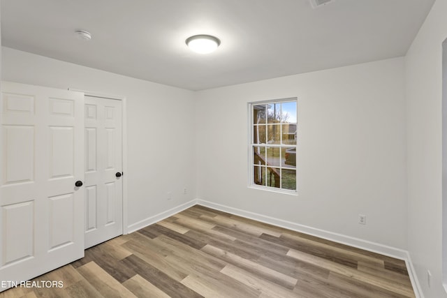 unfurnished bedroom with wood-type flooring and a closet