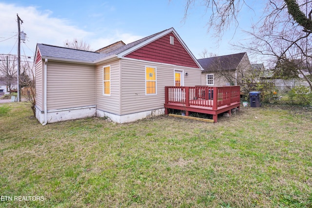 back of property featuring a lawn and a deck