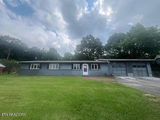 ranch-style home with a garage and a front lawn