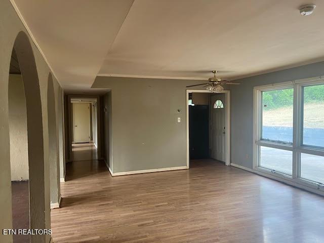 unfurnished room featuring ceiling fan, wood-type flooring, and crown molding