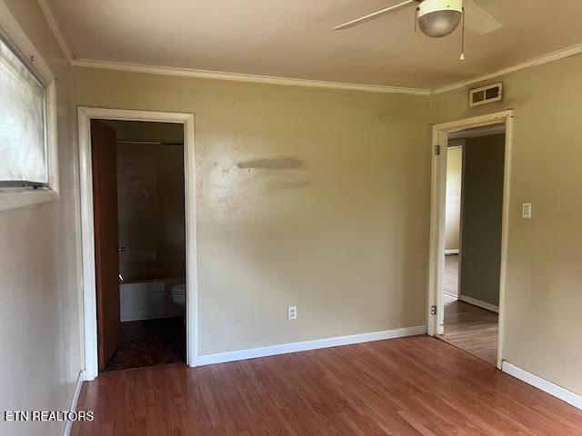 spare room with wood-type flooring, ceiling fan, and ornamental molding