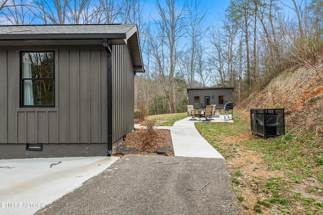 view of property exterior with a patio area and an outdoor structure