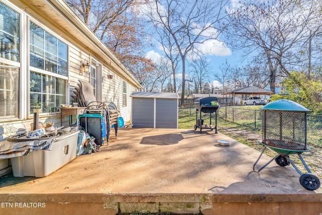 wooden deck with a storage shed and a patio