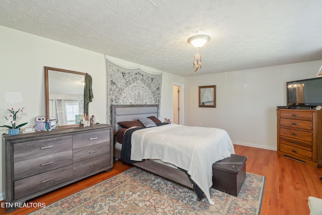 bedroom with hardwood / wood-style flooring and a textured ceiling