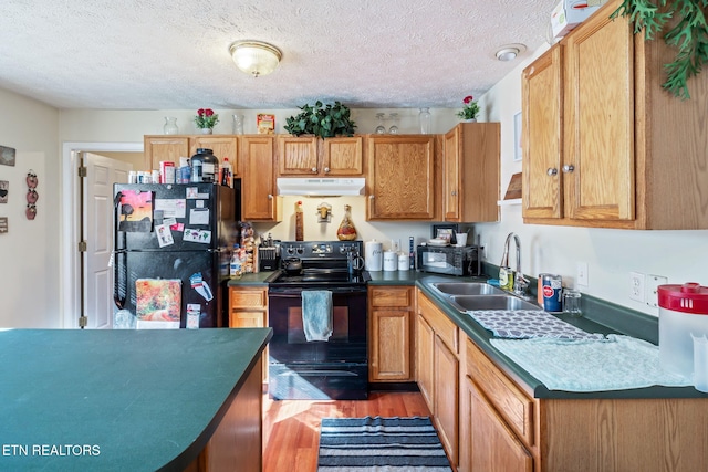 kitchen featuring black appliances, sink, a textured ceiling, and hardwood / wood-style flooring