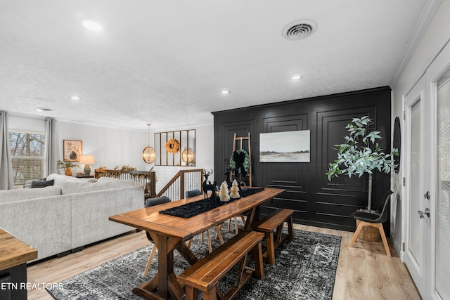 dining room with crown molding and light wood-type flooring