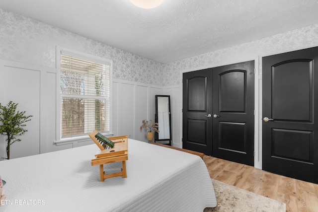 bedroom featuring wood-type flooring and a textured ceiling