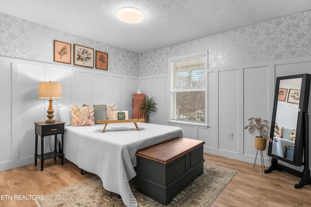 bedroom featuring light hardwood / wood-style flooring and a textured ceiling