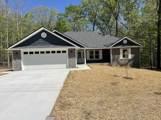 150 Hunterwood Ln, Fairfield Glade, TN 38558 - view of front facade featuring concrete driveway, a shingled roof, an attached garage, and brick siding