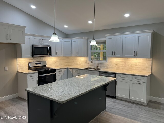 150 Hunterwood Ln, Fairfield Glade, TN 38558 - kitchen featuring stainless steel appliances, a sink, baseboards, light wood-style flooring, and lofted ceiling