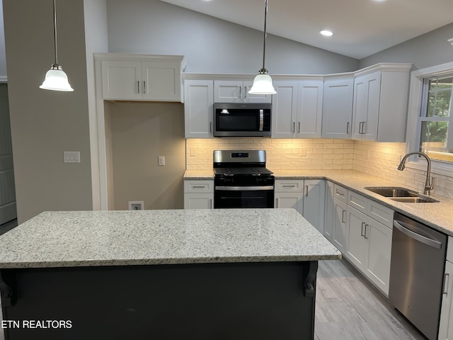 150 Hunterwood Ln, Fairfield Glade, TN 38558 - kitchen featuring appliances with stainless steel finishes, a sink, vaulted ceiling, a center island, and backsplash