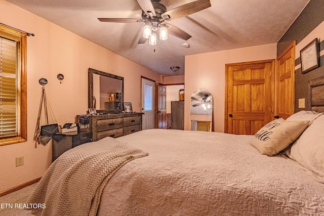 carpeted bedroom featuring ceiling fan and a textured ceiling