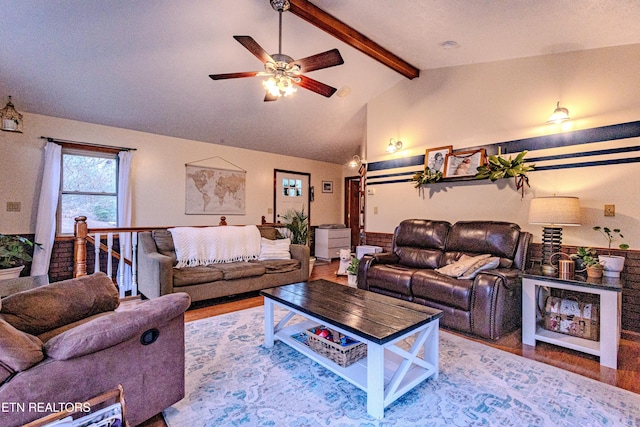 living room featuring lofted ceiling with beams, ceiling fan, and wood-type flooring