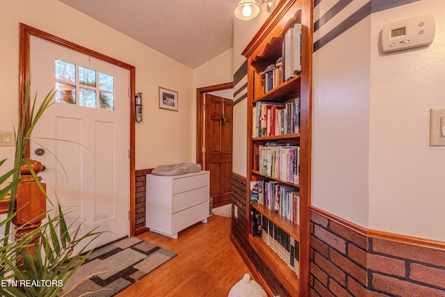 entrance foyer with light hardwood / wood-style flooring and vaulted ceiling