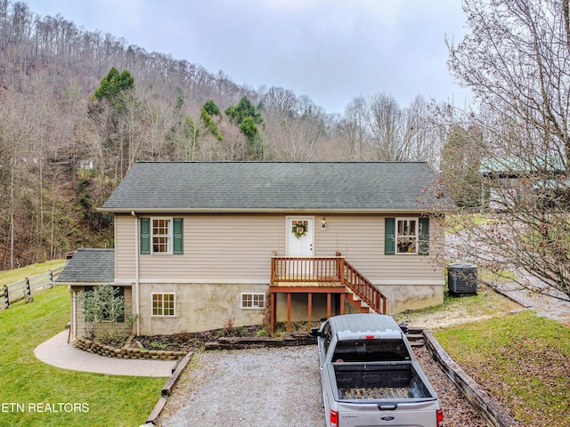 view of front of property featuring a front lawn and central AC unit