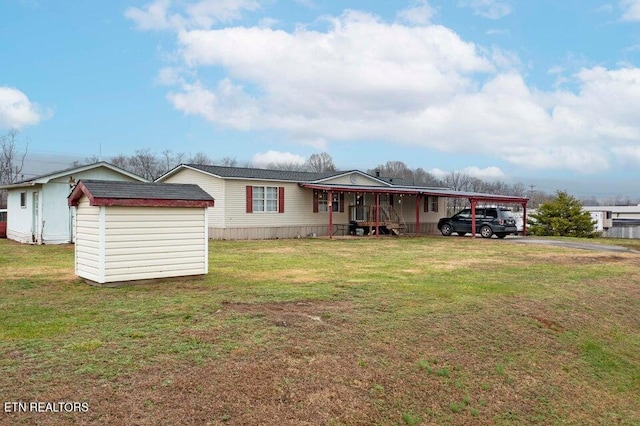 manufactured / mobile home featuring a carport, a storage unit, and a front yard