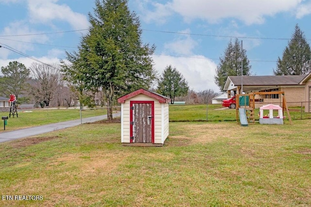 view of yard with a storage unit and a playground