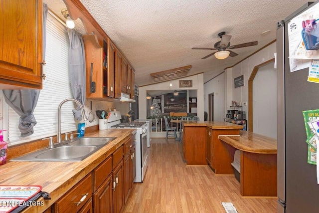 kitchen featuring white gas range, ceiling fan, sink, light hardwood / wood-style flooring, and stainless steel refrigerator