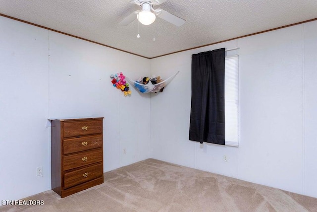 carpeted spare room featuring ceiling fan and a textured ceiling