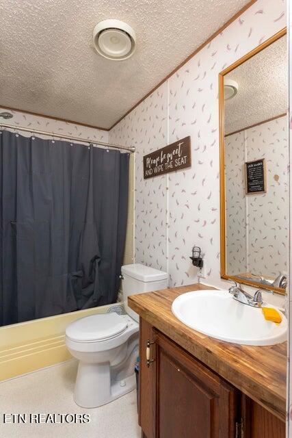 bathroom with curtained shower, vanity, a textured ceiling, and toilet