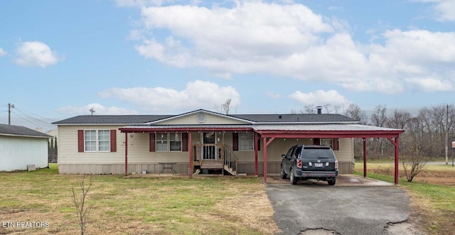 manufactured / mobile home with a carport and a front yard