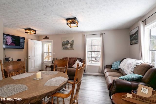 dining space featuring hardwood / wood-style floors and a textured ceiling