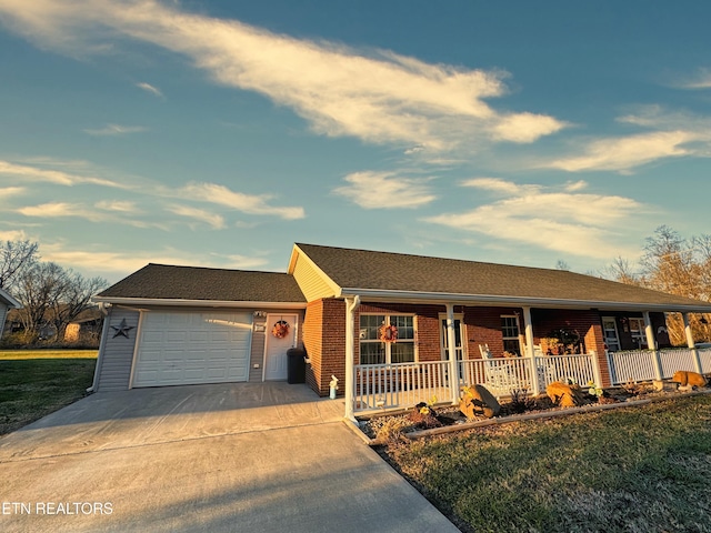 ranch-style house with a garage, covered porch, and a front lawn