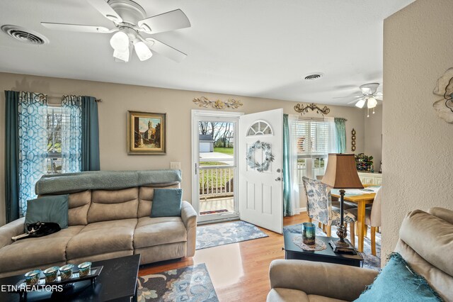 living room with ceiling fan and light wood-type flooring