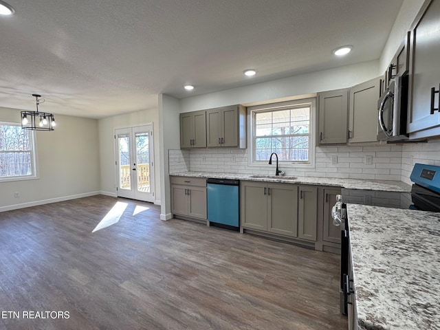 kitchen featuring stainless steel appliances, sink, pendant lighting, and dark hardwood / wood-style floors